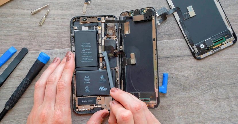 Tay cầm và tháo rời pin từ iPhone, công cụ sửa chữa xung quanh trên bàn làm việc